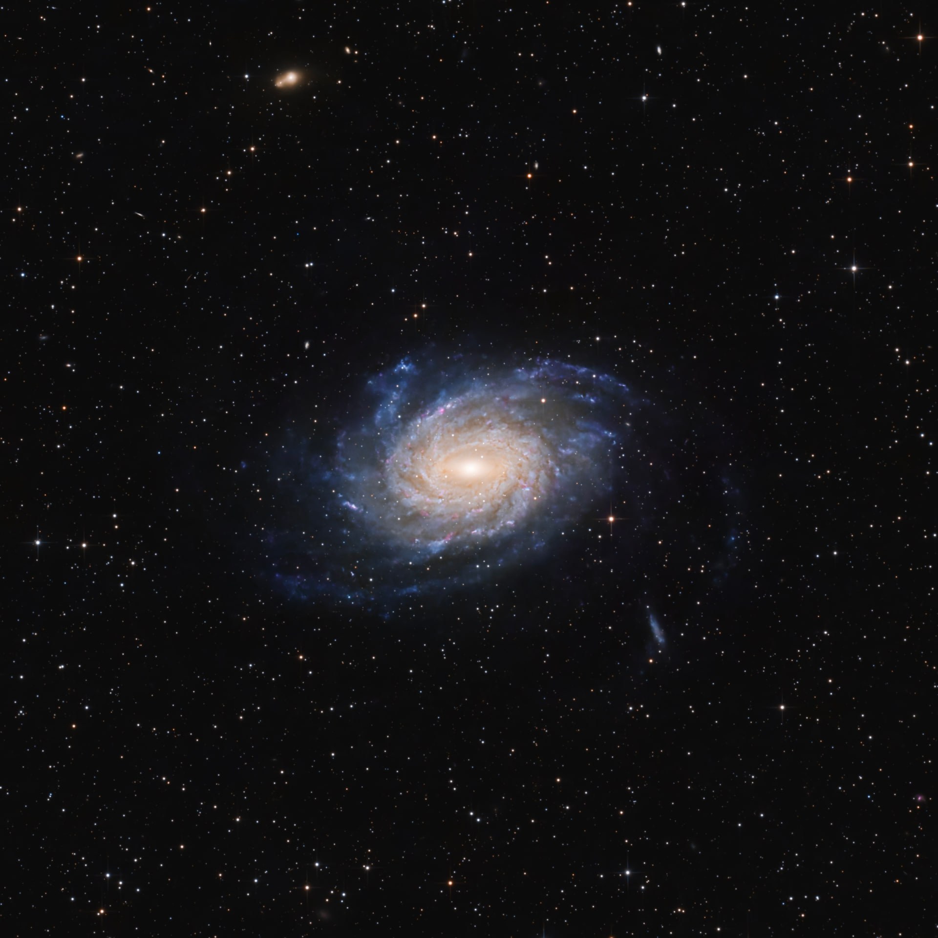 The spiral galaxy NGC 6744 showing a warm centre and faint blue arms against black space.