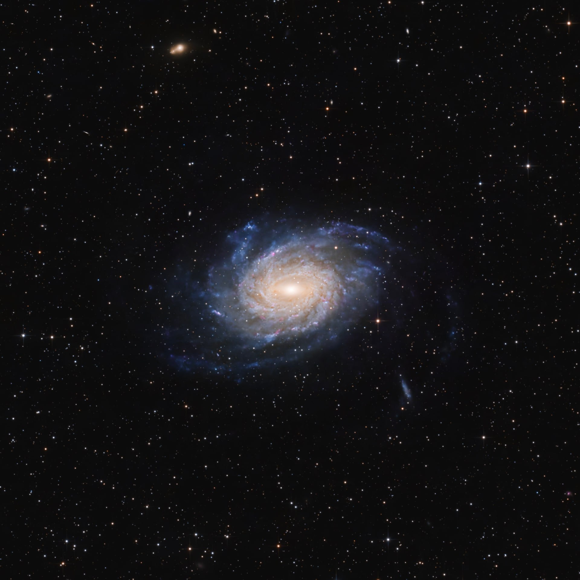 The spiral galaxy NGC 6744 showing a warm centre and faint blue arms against black space.