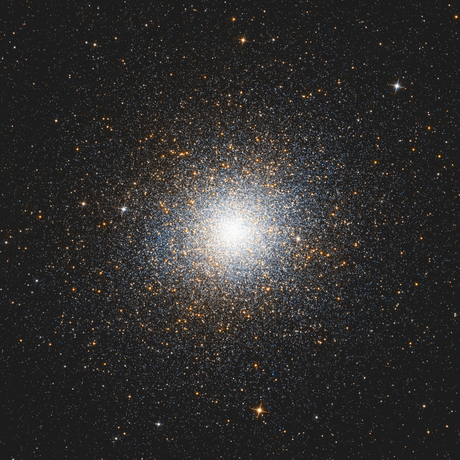 Omega Centauri forming a densely packed sphere of warm stars on a dark background.