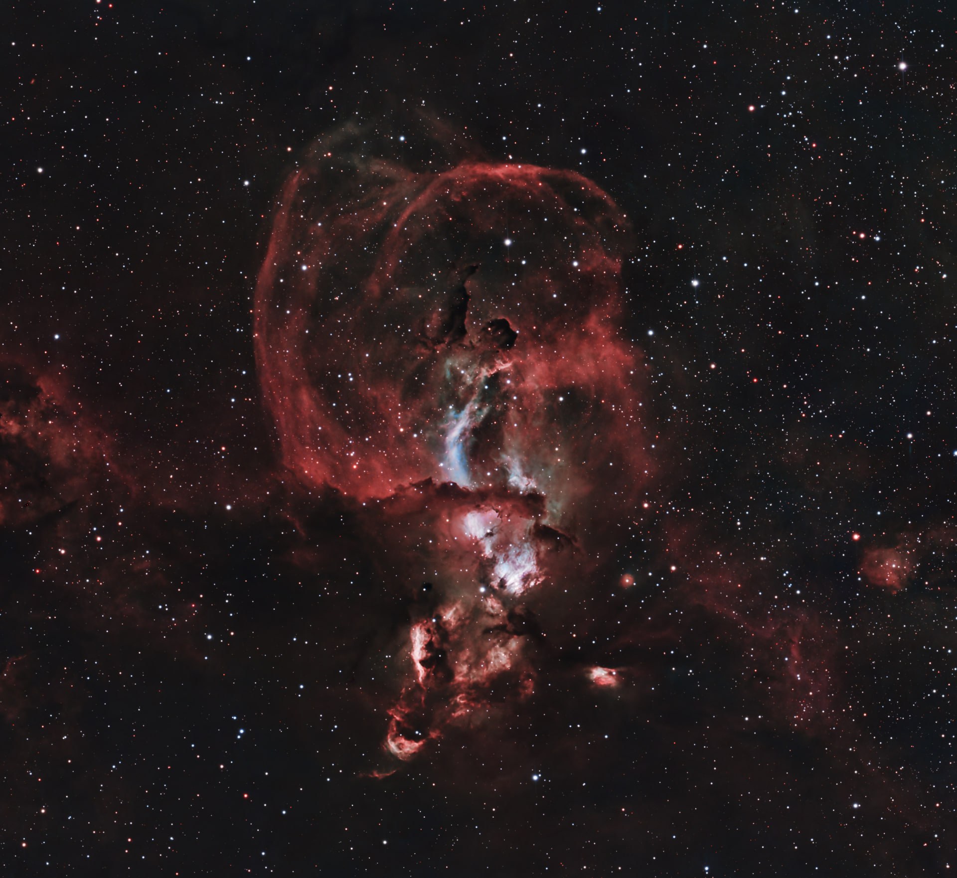 The Statue of Liberty Nebula appearing as a tall red emission structure in a dense star field.