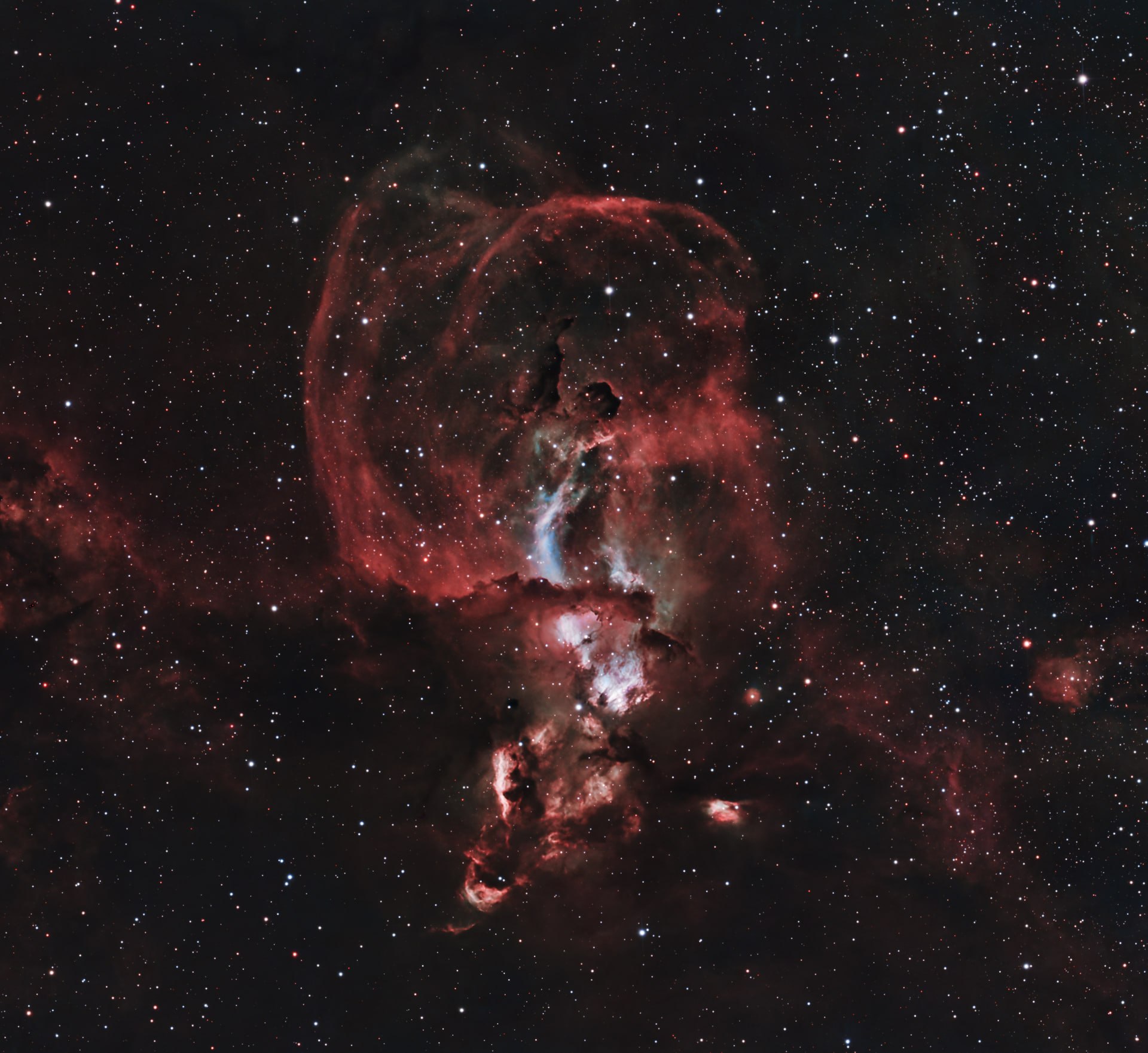 The Statue of Liberty Nebula appearing as a tall red emission structure in a dense star field.